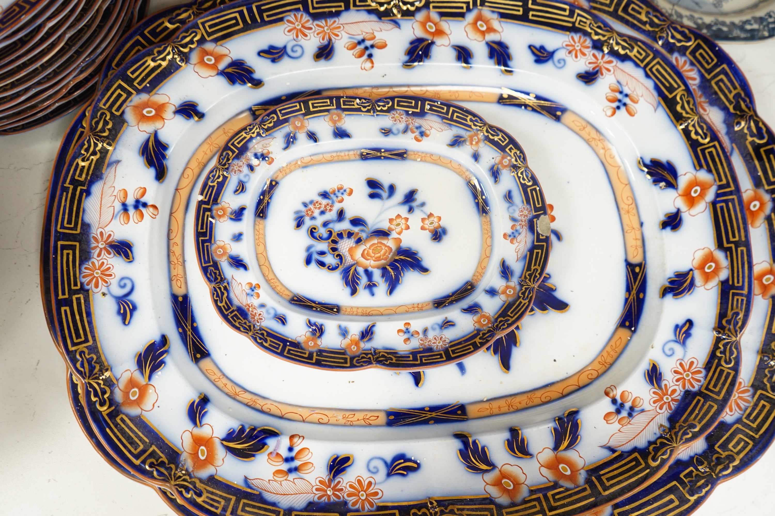 A Staffordshire flow blue ironstone part dinner service, comprising twenty-two 26.5cm diameter plates, seven 23.5cm diameter plates, ten 26.5cm diameter dishes, two small serving dishes and three large serving dishes, la